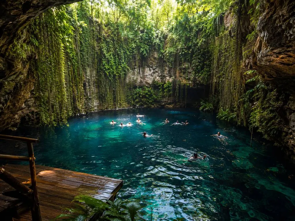 Nadadores en un cenote de agua dulce cerca de Playa del Carmen